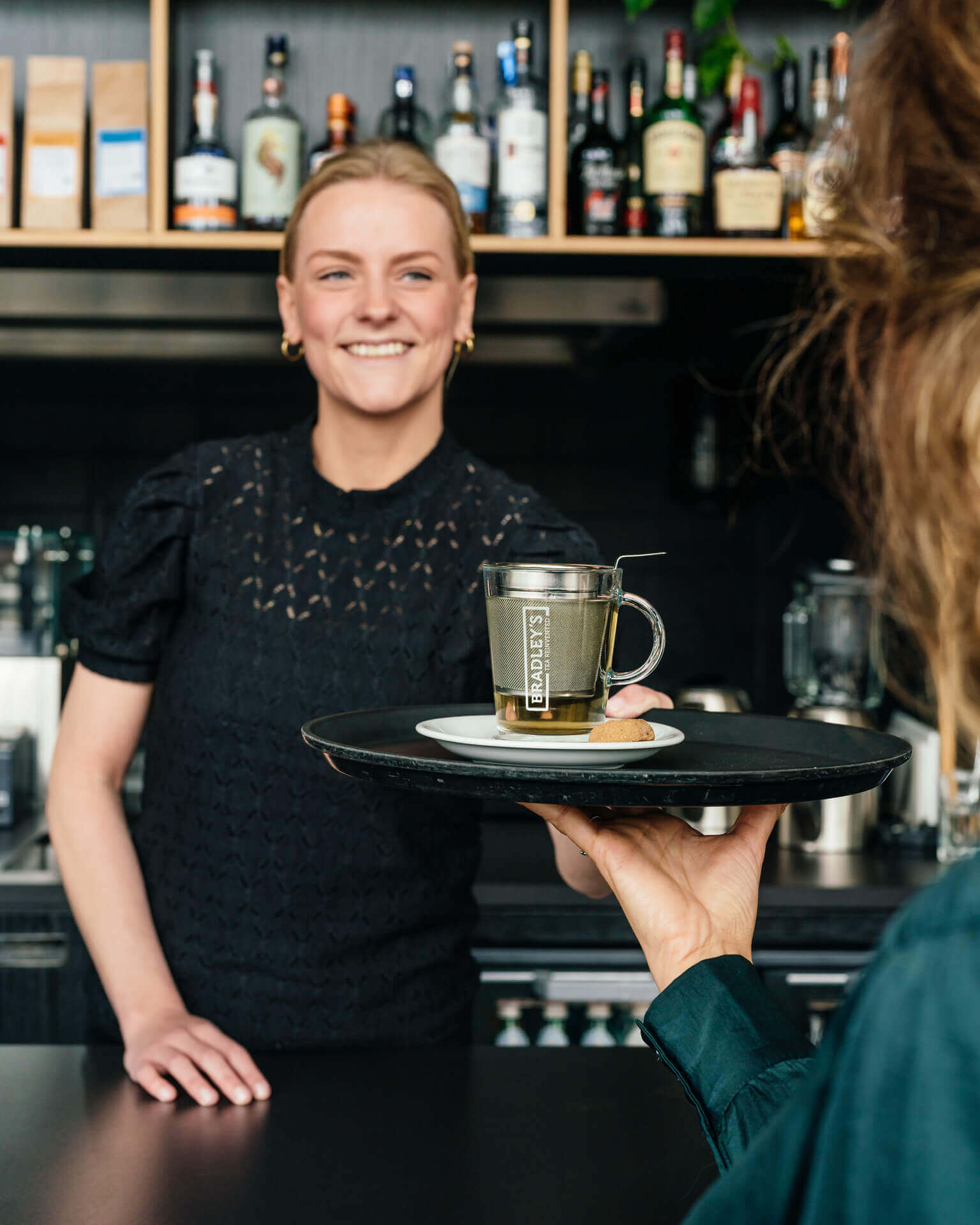 Bradley’s thee geserveerd in een moderne koffiezaak met latte art en gebak.